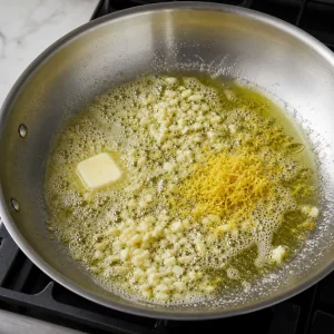Чеснок и лимонная цедра шипят в сливочном и оливковом масле