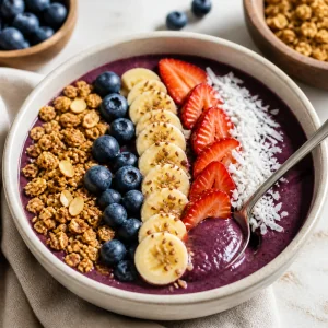 Finished acai-blueberry smoothie bowl served immediately with a spoon