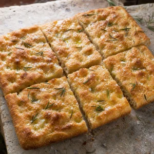 Finished Roman-style pizza bianca with rosemary, olive oil, and flaky sea salt