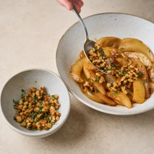 Toasted walnuts and fresh thyme are mixed into warm honeyed pears with a small garnish portion reserved.