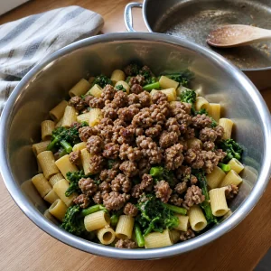 Browned sausage added to pasta and broccoli rabe