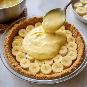 Warm custard spooned over banana slices in the crust