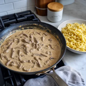 Creme azedo misturado ao strogonoff de carne antes de servir com massa