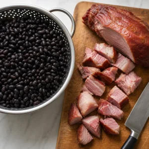 Haricots noirs trempés et porc fumé coupé sur une planche