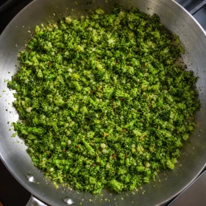 Chopped broccoli cooking with garlic oil and lemon zest