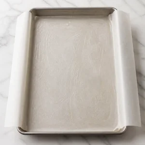 Parchment-lined rimmed sheet pan ready for batter