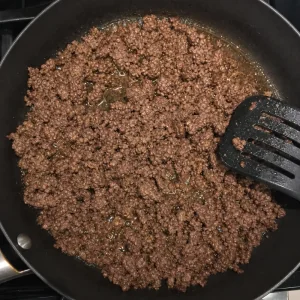 Carne macinata rosolata in padella con grasso in eccesso da scolare