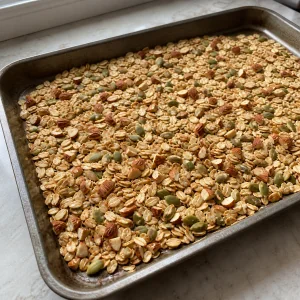 Avena, mandorle e semi di zucca distribuiti su una teglia