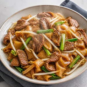 Heißes Beef Chow Fun auf einem Teller serviert