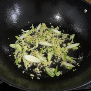 Scallion whites and ginger sizzling in oil