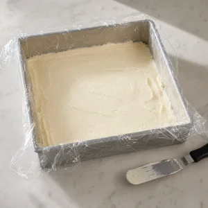 Glace à la vanille étalée dans un moule carré chemisé