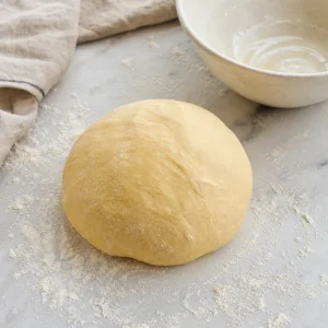 Smooth kneaded dough on a floured counter