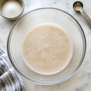 Foamy yeast mixture in a mixing bowl