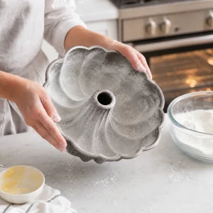 Untar e enfarinhar uma forma bundt para bolo de limão com sementes de papoila.