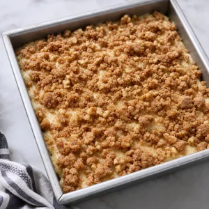 Unbaked coffee cake topped with cinnamon streusel