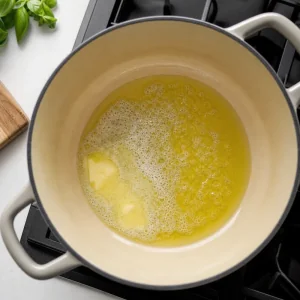 Butter and olive oil melting in a large pot for tomato basil soup.