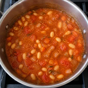 Tomaten-Bohnensuppe köchelt offen mit weichen weißen Bohnen