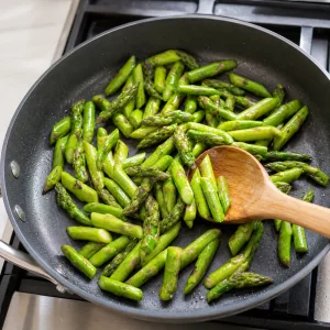 Asparagus pieces sautéing in the skillet until bright green and tender-crisp.