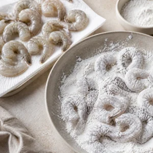 Raw shrimp patted dry and coated evenly in cornstarch.
