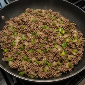 Carne moída dourando com cebola e pimentão verde