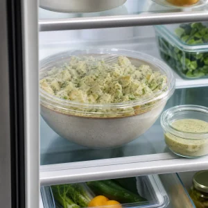 Covered potato salad and dressing chilling in the refrigerator