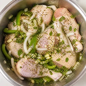 Raw chicken pieces seasoned with onion, green pepper, garlic, oregano, and cilantro