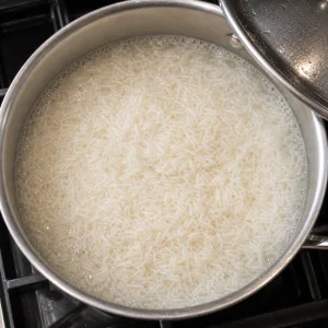 White rice simmering with water in a saucepan