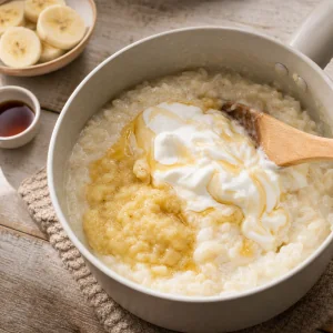 Griechischer Joghurt und Honig werden in warmen Milchreis gerührt