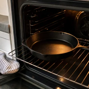 Empty cast-iron skillet preheating on the middle oven rack.