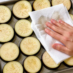 Fette di melanzana asciugate con carta da cucina