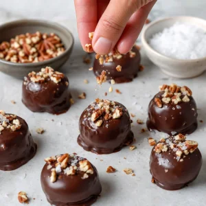 Bocaditos de banana cubiertos de chocolate con nueces pecanas tostadas y sal marina en escamas