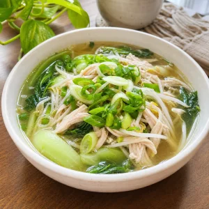 Ginger chicken soup served with mung bean sprouts and green onions