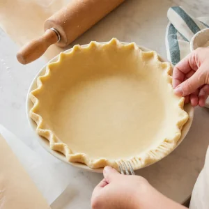 A franzir a massa sem glúten numa forma de tarte