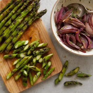 Asperges grillées coupées en biais avec oignons à côté