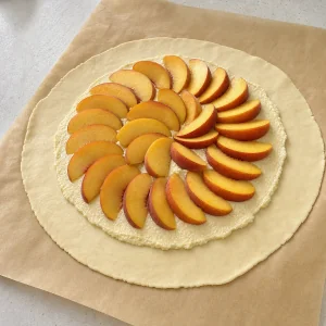 Pfirsiche auf Mandelfüllung und rohem Galetteteig