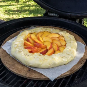 Rohe gefaltete Pfirsich-Galette auf dem Pizzastein