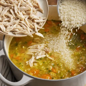 Shredded chicken and white rice added to the soup pot