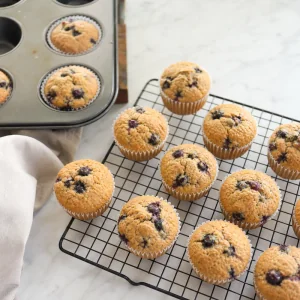 Blueberry protein muffins cooling on a wire rack after baking