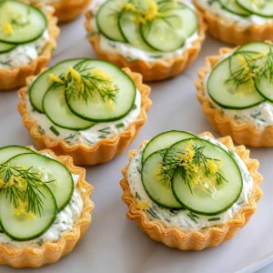Tortinhas com pepino decoradas com endro fresco e raspas de limão.