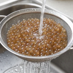 Perle di tapioca cotte sciacquate con acqua fredda in un colino fine