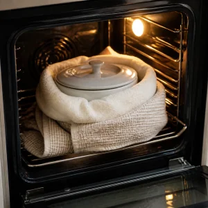 Covered yogurt pot wrapped in towels for warm overnight incubation