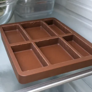 Cascas de chocolate ao leite endurecidas em molde de silicone refrigerado