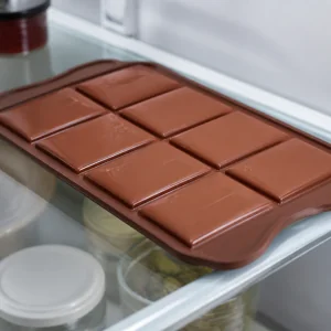 Barras de chocolate seladas descansando no molde na geladeira até firmarem
