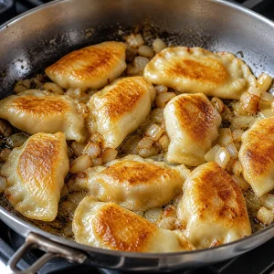 Pierogi cozidos fritos com manteiga e cebola até ficarem dourados e crocantes