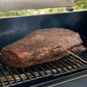 Pfefferverkrustete Brust rauchert langsam auf dem Rost des Smokers