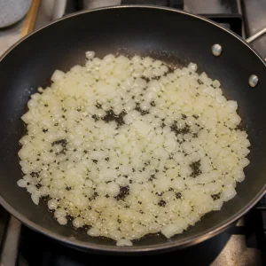 Cipolla tritata che si ammorbidisce nell olio in padella