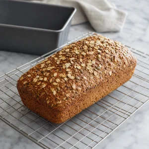 Finished seeded multigrain bread cooling on a wire rack before slicing