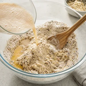 Foamy yeast mixture and melted butter mixed into dry ingredients to form shaggy dough