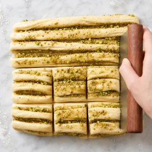 Filled dough strips stacked and cut into square portions