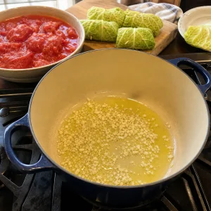 Ail en train de cuire dans l’huile d’olive avec des tomates écrasées prêtes pour la sauce
